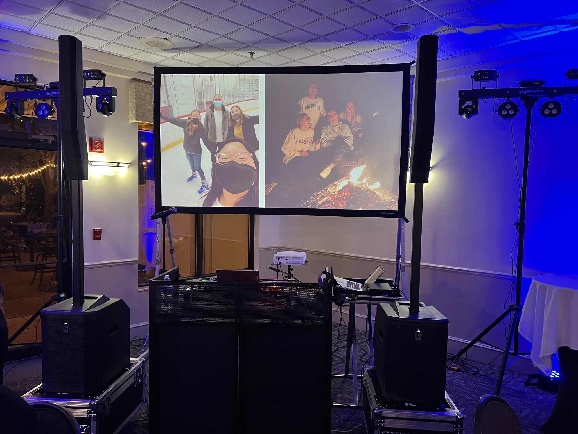 Dorian's DJ Setup with speakers, turntable, up lighting, and a reverse projection screen displaying some pictures