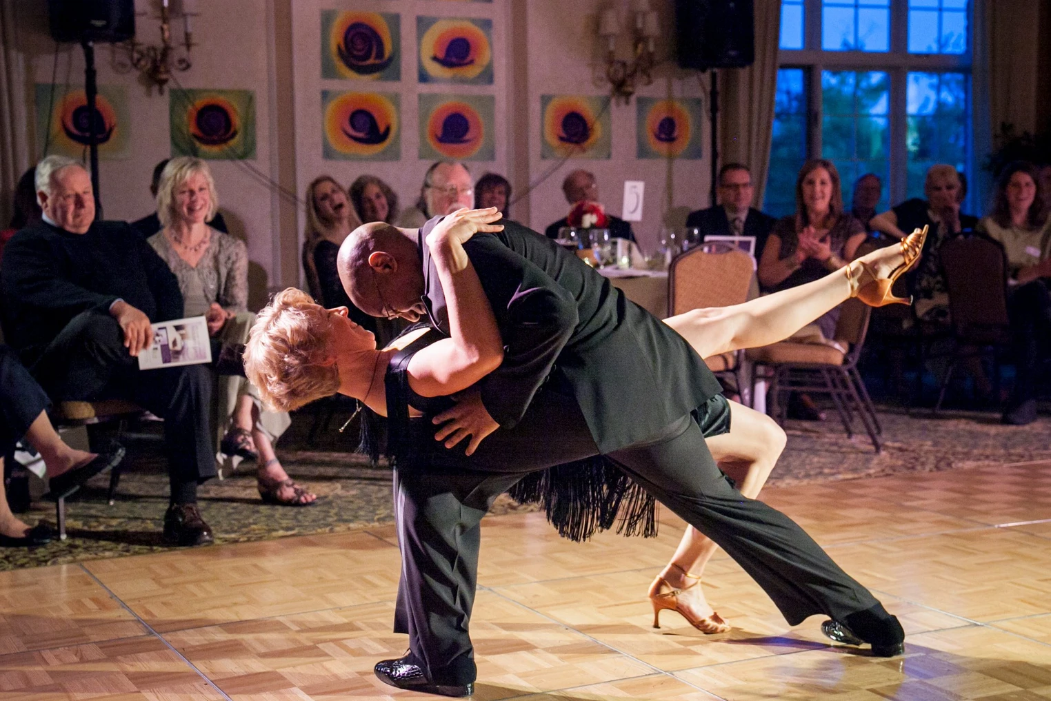 Dorian dipping his dance partner as people clap in the background